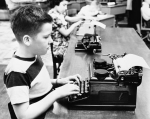 Boy and girl (6-7) using typewriters